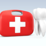 A white tooth floats next to a red and white emergency first aid kit against a gray background